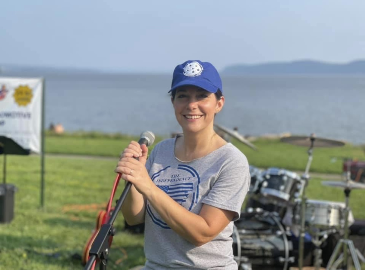 a woman wearing a blue hat and holding a mike